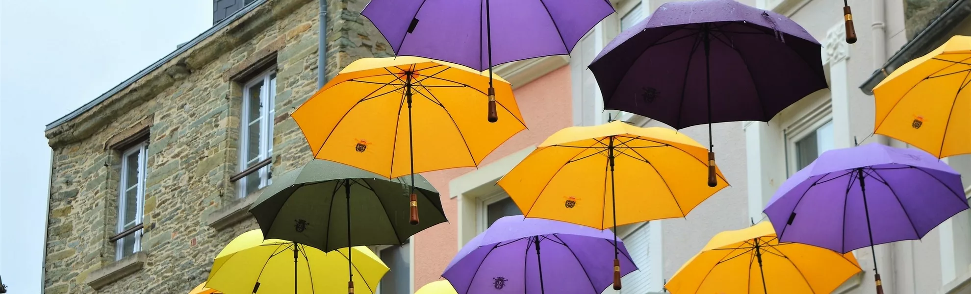 Regenschirme hängen in einer Straße in Cherbourg - © Tanoz - stock.adobe.com