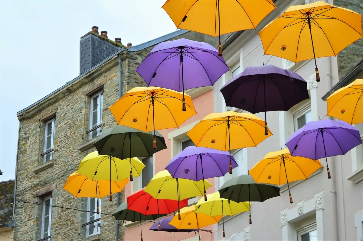 Regenschirme hängen in einer Straße in Cherbourg - © Tanoz - stock.adobe.com